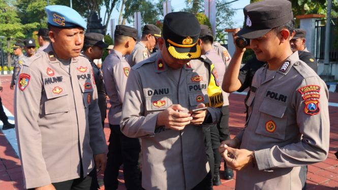 Wakapolres Gresik memeriksa HP anggota soal judi online.