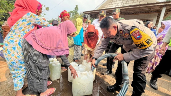 Polisi saat mendistribusikan air bersih di Mojokerto