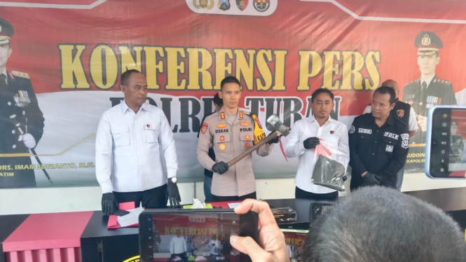 Polisi menunjukkan kapak yang digunakan untuk menganiaya korban