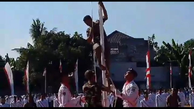 Anggota Satpol PP Lamongan panjat tiang bendera.