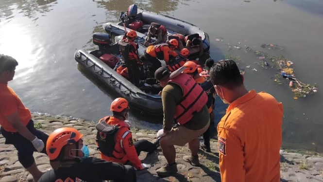 Petugas BPBD Surabaya mengevakuasi mayat di Kalimas Surabaya.