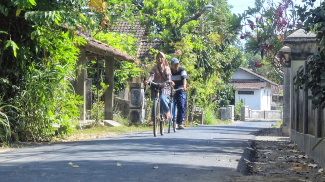 Warga Desa Nyawangan melintas di jalan hotmik realisasi BKK