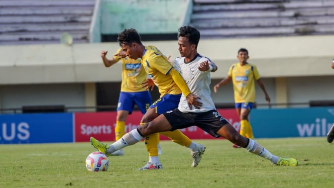 Pemain Gresik United (kuning) mencoba lepas dari hadangan pemain Rans Nusantara.