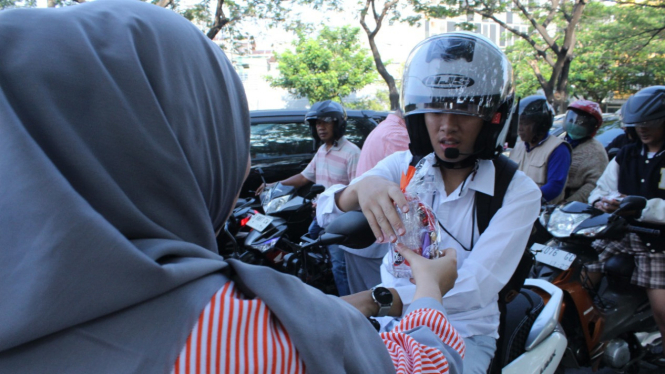 Tenaga medis saat membagikan bingkisan ke pengendara.