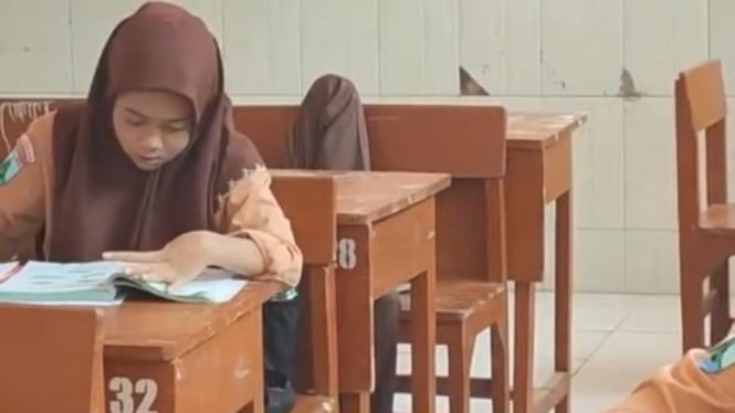 Nampak salah seorang siswa sedang tiduran di kelas