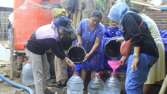 Warga mengisi air bersih dari KAUJE Korda Trenggalek.