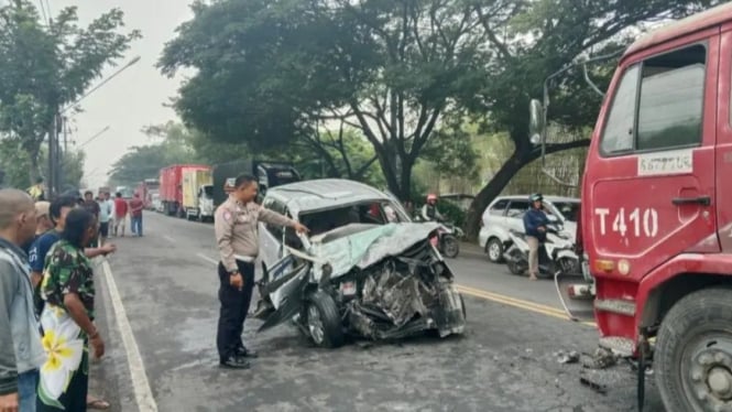 Petugas kepolisian di lokasi kecelakaan adu banteng antara mobil Avanza dengan truk tronton di Jalan Raya Cangkringmalang, Kecamatan Beji, Pasuruan, Minggu (24/11/2024) pagi.