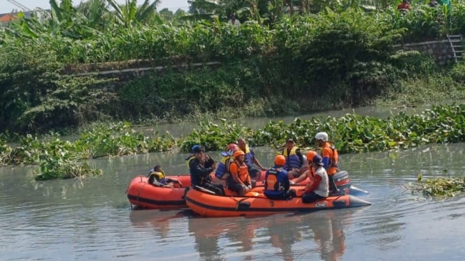 Tim gabungan saat mencari korban terseret arus selokan.