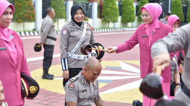 Kasi Humas Polres Gresik Iptu Wiwit mendapatkan siraman saat kenaikan pangkat.