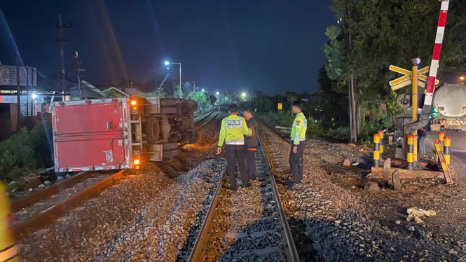 Truk terguling di perlintasan kereta api