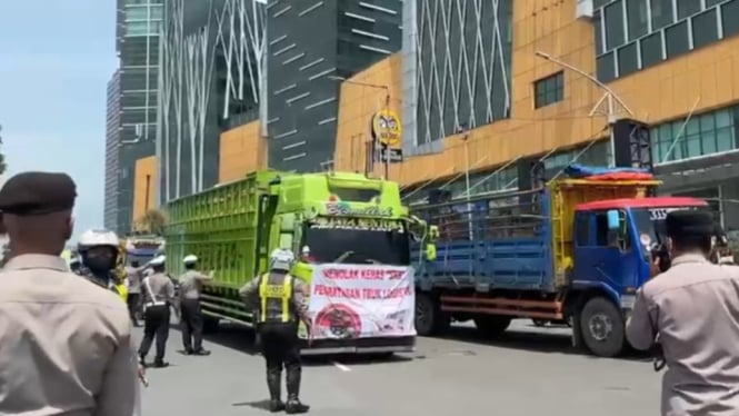 Truk pengunjuk rasa memasuki Kota Surabaya melalui Bundaran Waru, Sidoarjo.