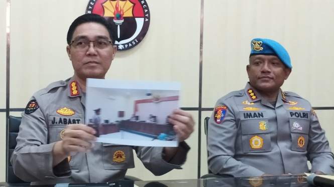 Jules menunjukkan foto suasana sidang kepada awak media.