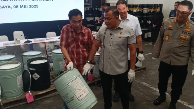 Drum berisi cairan sianida ilegal dan petugas kepolisian saat di lokasi penyimpanan.