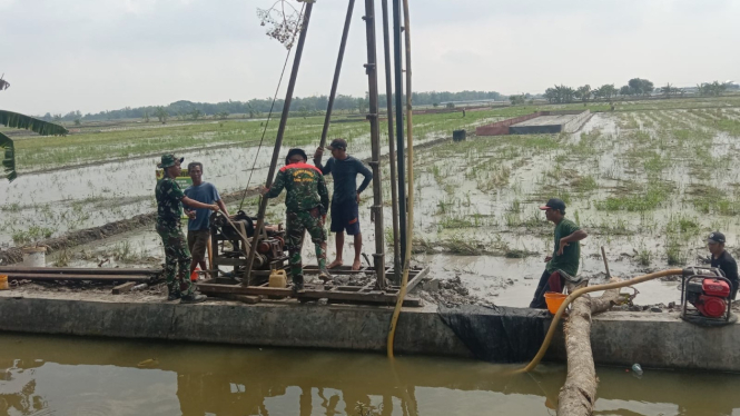 Petugas TNI dan warga saat melakukan pengeboran sumur.