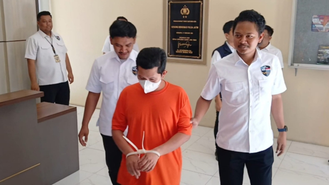 Tersangka digelandang polisi.