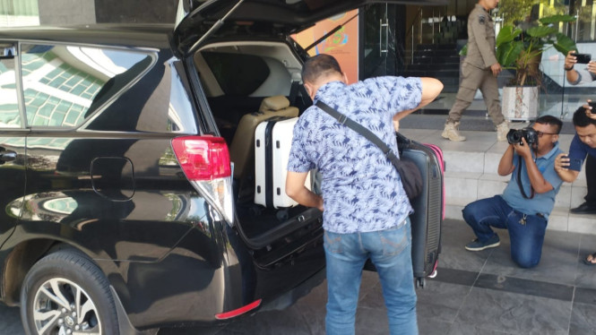 Petugas saat memasukan koper