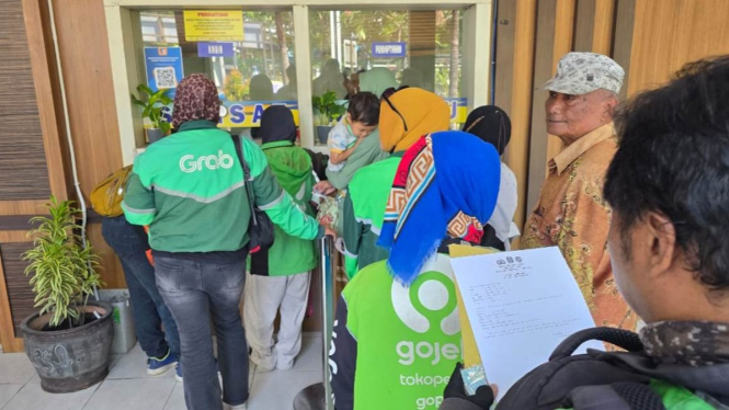 Tukang ojek online mengurus pajak kendaraan di Surabaya.