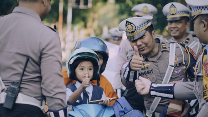 Polisi Gresik bagi-bagi helm ke anak-anak.