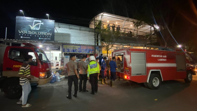 Petugas saat memadamkan api yang membakar toko kelontong di Jl. KH Ahmad Dahlan Lamongan