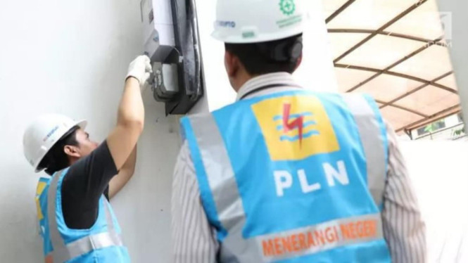 Petugas PLN saat memasang instalasi di rumah pelanggan
