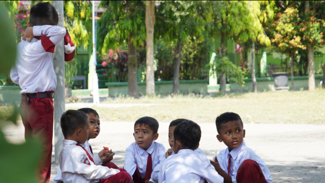 Restu bermain dengan teman-temannya di sekolah.