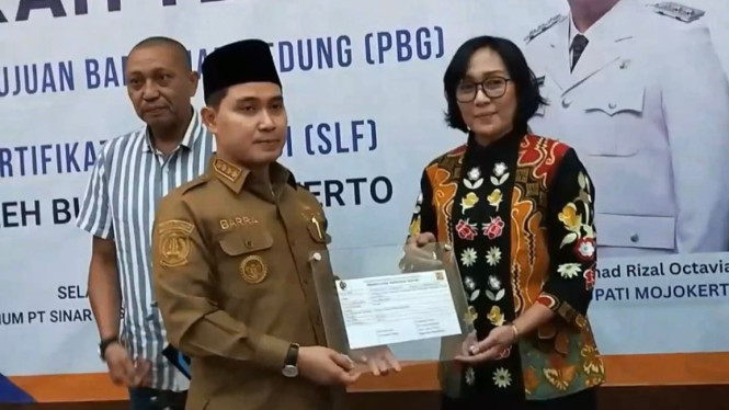 Bupati Mojokerto menyerahkan sertifikat PBG-SLF kepada pelaku usaha.