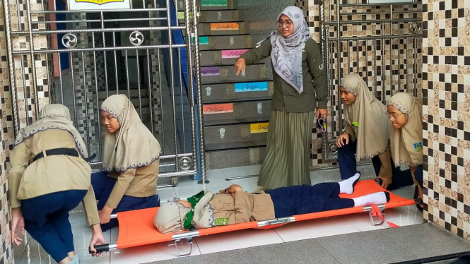 Simulasi hadapi bencana gempa di SD Muhammadiyah 18 Surabaya.