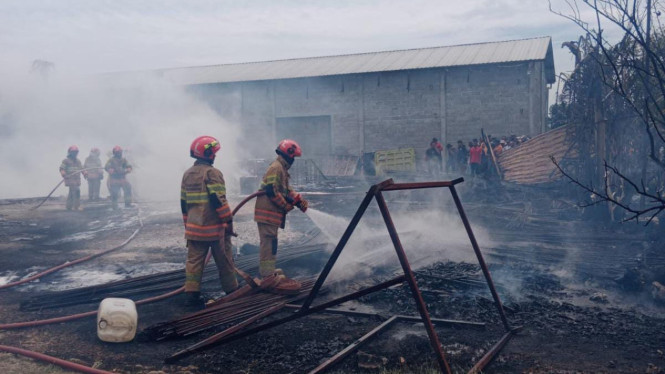 Petugas memadamkan api di gudang solar yang terbakar di Bojonegoro.