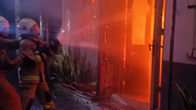 Petugas damkar padamkan api di kawasan padat di Surabaya.