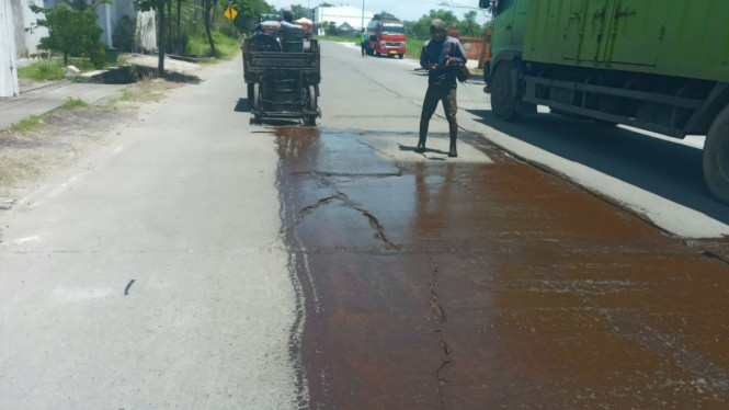 Pekerja sedang melakukan perbaikan jalan.