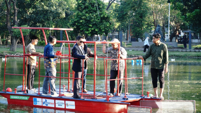 Rektor ITS Prof Dr (HC) Ir Bambang Pramujati ST MScEng PhD (berjas) bersama tim peneliti Kapal Pembersih Sampah Tanpa Awak melakukan uji coba kapal.