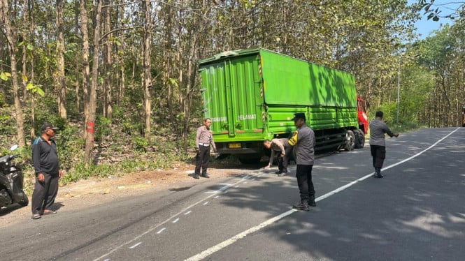 Polisi Melakukan Olah TKP Kecelakaan Truk dan Motor di Kawasan Alas Kemlagi, Kabupaten Mojokerto.
