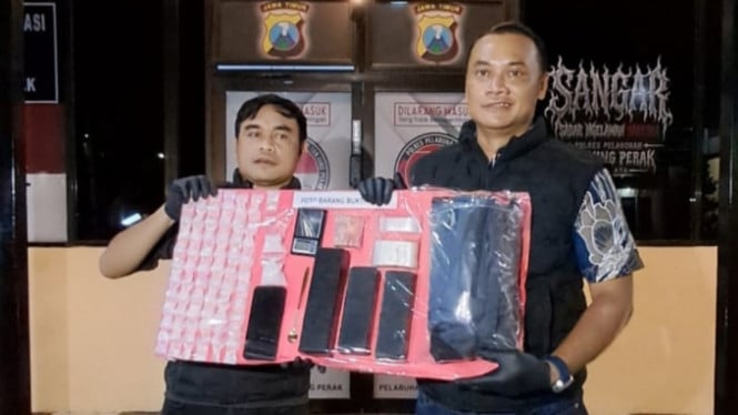 Petugas kepolisian menunjukkan barang bukti