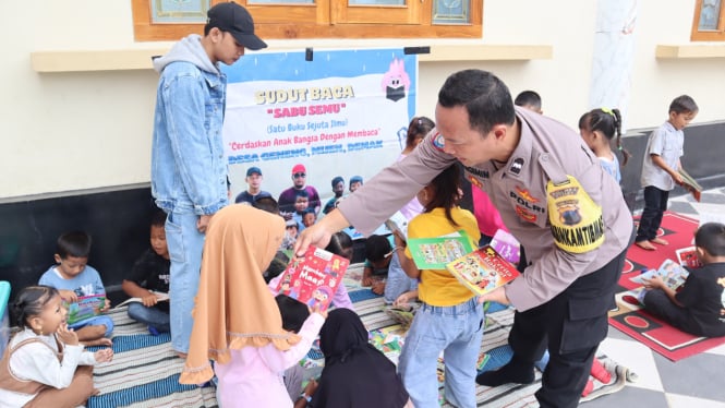 Aipda Sugimin saat membagikan buku kepada anak-anak