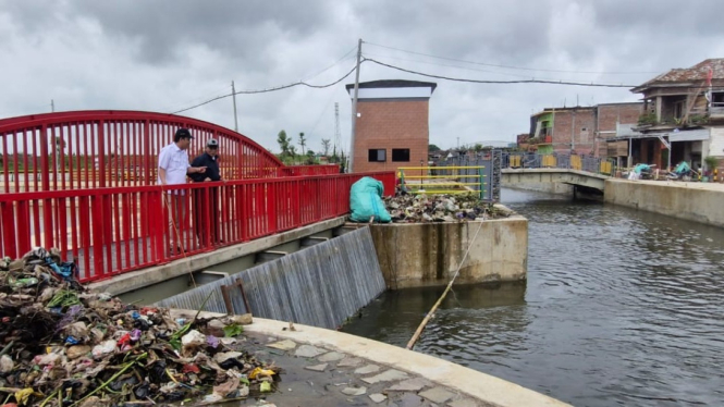 Tumpukan sampah menghambat aliran air kolam retensi