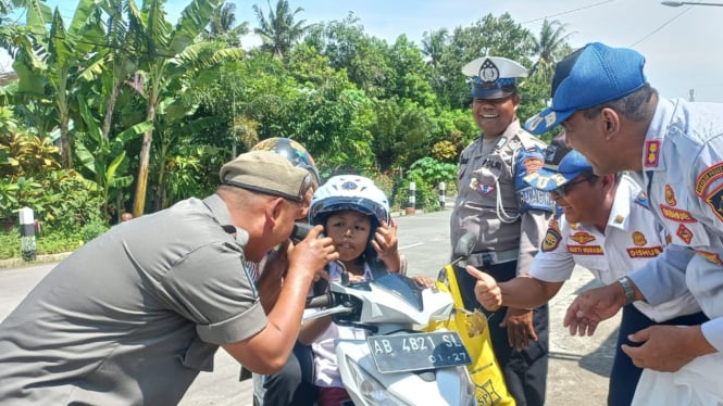 Membagi helm SNI dalam rangka operasi gabungan di jalan provinsi