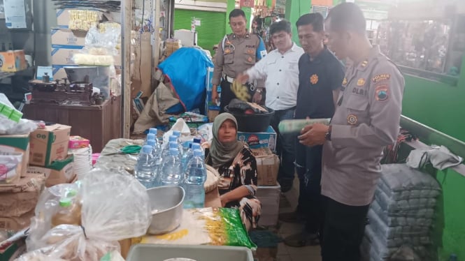 Anggota Polsek memeriksa ketersediaan bahan pangan di pasar Kudus.