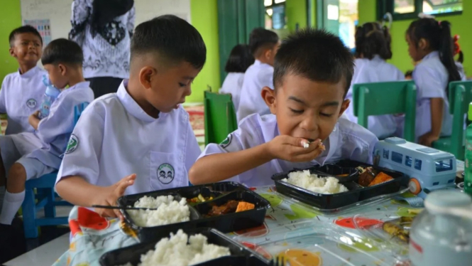 Dua bocah menikmati Makan Bergizi Gratis