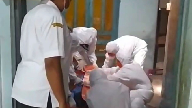 Petugas tengah mengevakuasi jenazah warga