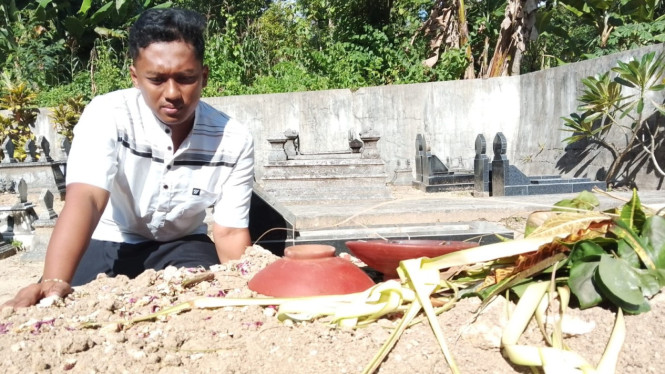 Kakak korban, Rafiq Nur Setiawan di makam almarhum Ilham Dwi Saputra