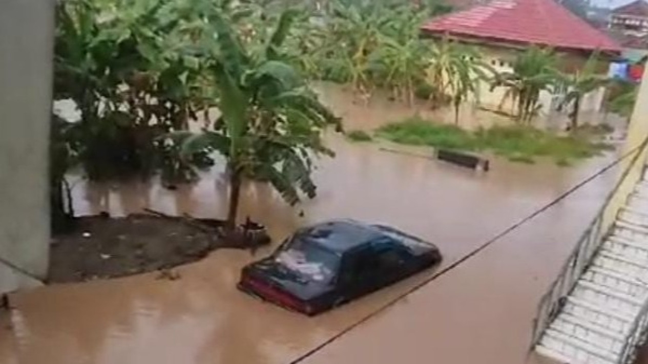 Banjir merendam mobil di pemukiman warga.