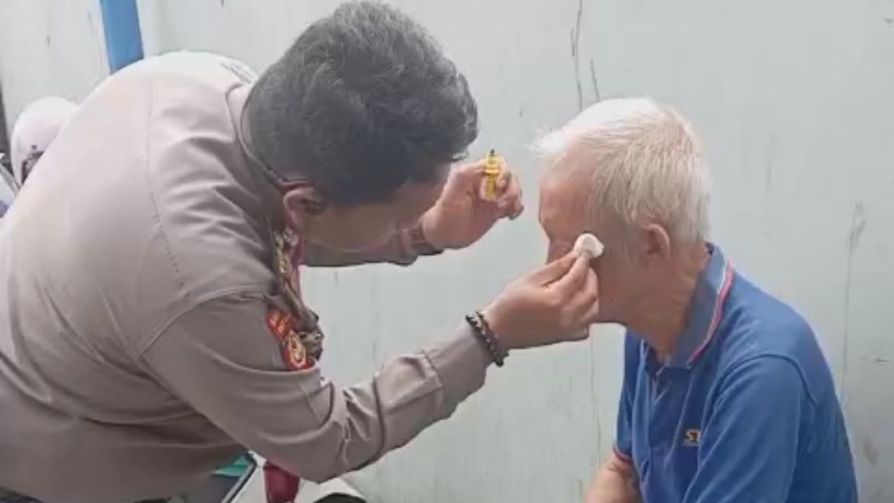 Perwira Polda Lampung membantu kakek korban kecelakaan tunggal.