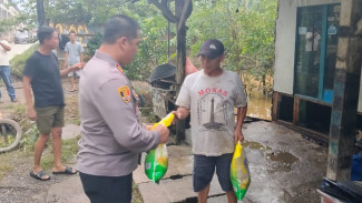 Sigap! Di Sela Pengamanan Nataru, Polsek Natar Terjang Banjir dan Bantu Warga