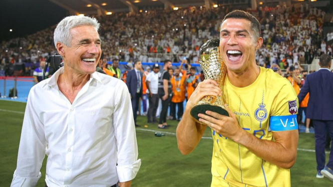 Cristiano Ronaldo dari Al Nassr merayakan kemenangan dengan trofi