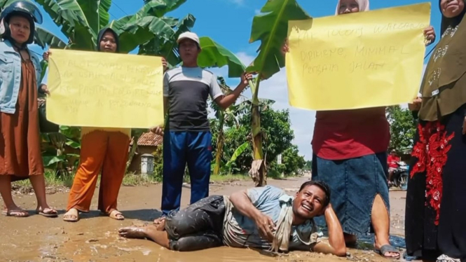 Warga berpose di Jalan Rusak