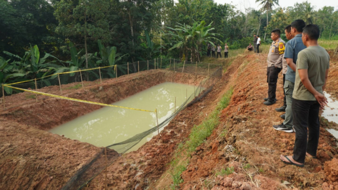 Polisi mengecek kolam ikan yang menjadi lokasi tewasnya 3 anak.