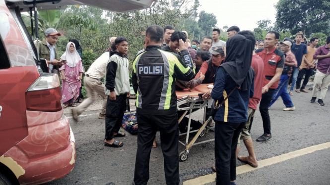 Polisi mengevakuasi korban kecelakaan bus masuk ke dalam jurang.