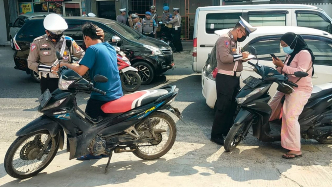 Polisi melakukan penindakan terhadap pelanggar lalulintas.