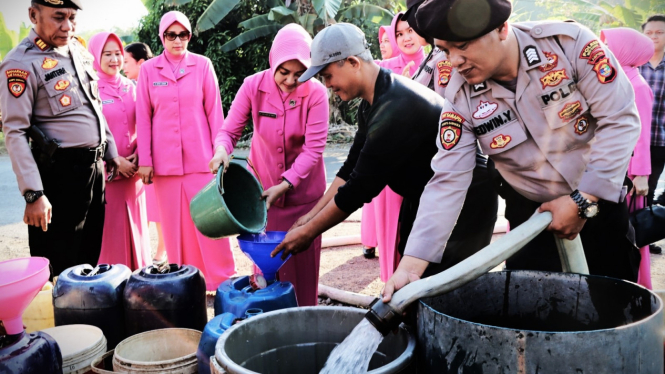 Polres Way Kanan membagikan air bersih ke warga.