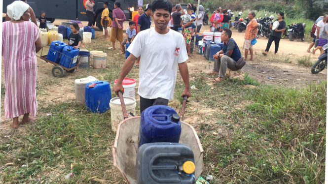 Warga angkut bantuan air bersih pakai gerobak sorong